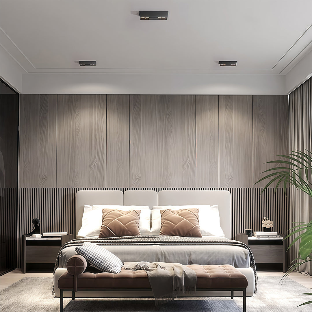 Black surface-mounted square downlights providing stylish illumination in a modern bedroom with a wood accent wall.