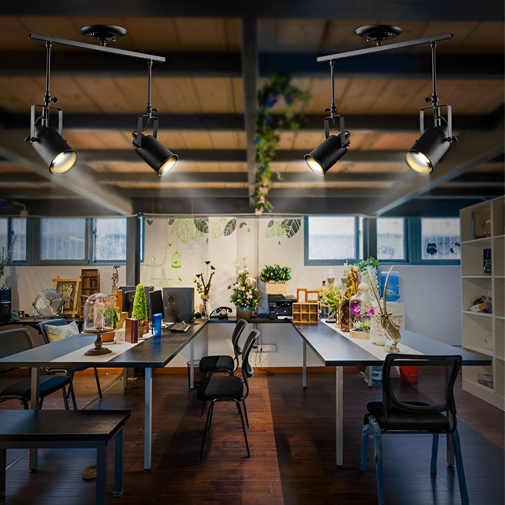 Black track light system casting warm light over a wooden bar area in a restaurant.