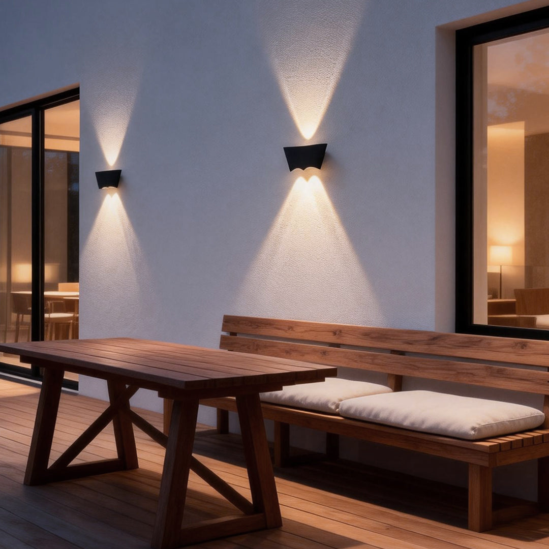 Black up down wall light mounted beside an outdoor dining area, creating warm ambient lighting for evening gatherings.