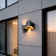 Black up down wall lights with a modern geometric design, mounted beside a large window.