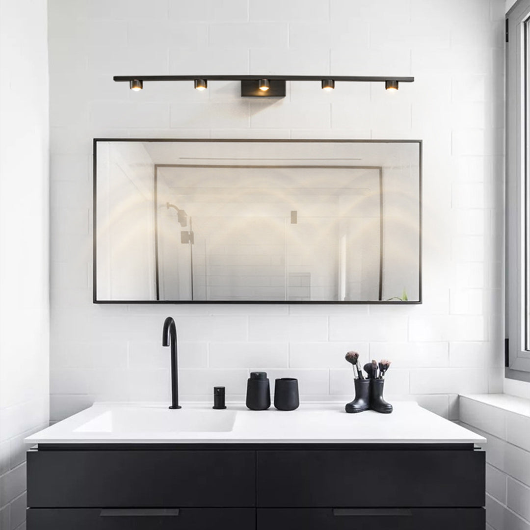 Black vanity lights for bathroom installed above contemporary mirror in luxury modern bathroom setting