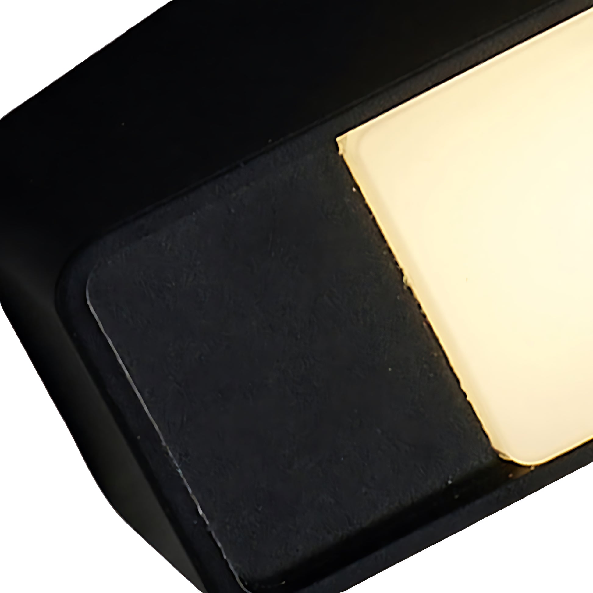 Close-up corner detail of black wall light showing angular design and LED diffuser edge