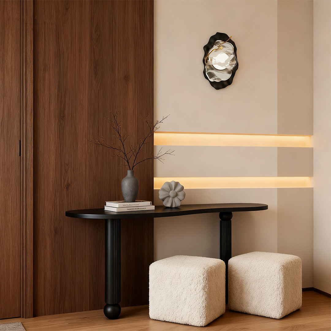 Black wall light illuminating contemporary dining nook with wood paneling and neutral ottomans