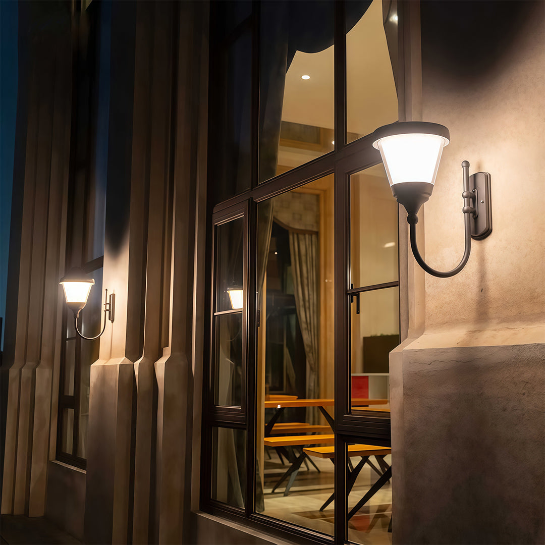 Black outdoor wall light casting bright light on a textured wall, adding to the outdoor atmosphere.