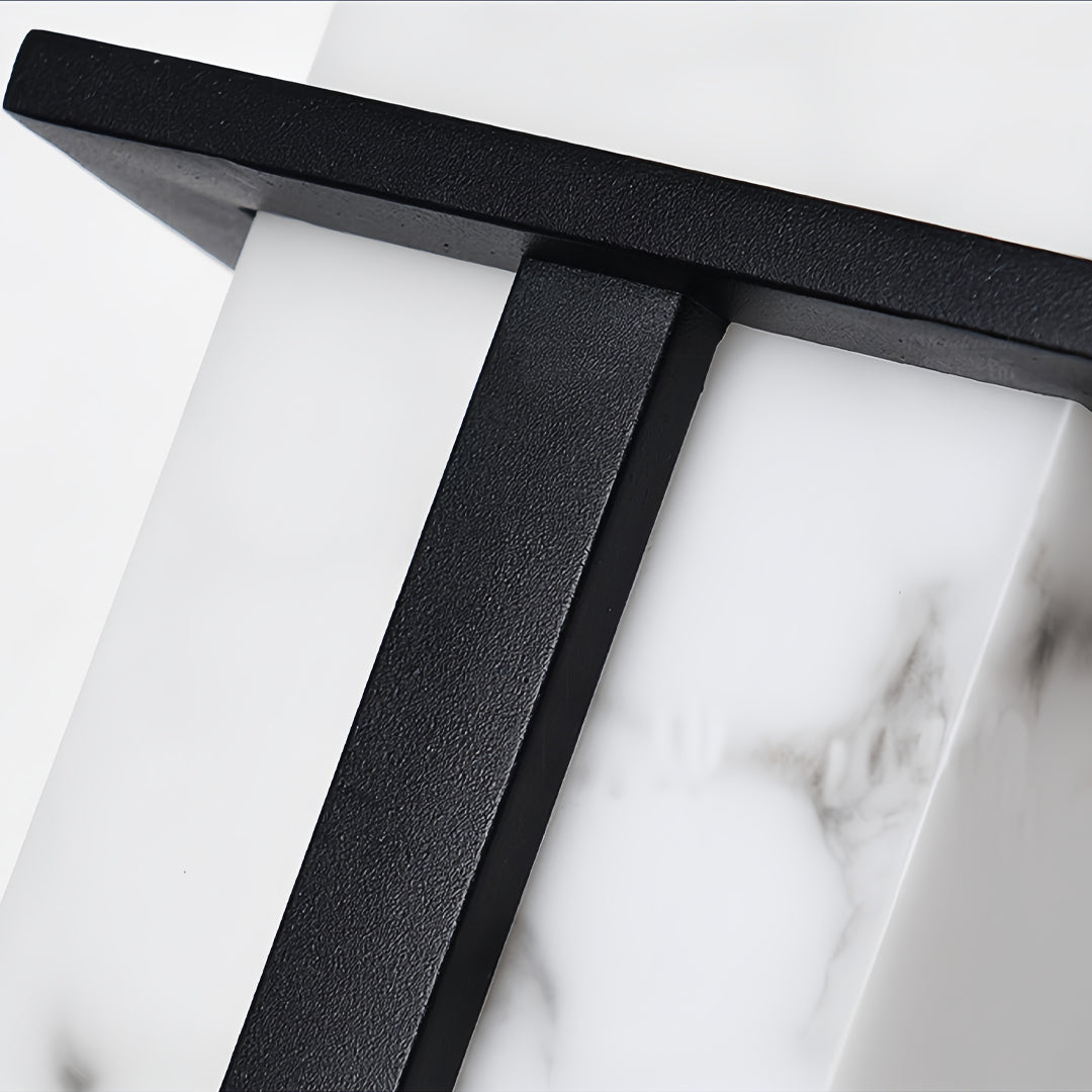 Close-up detail of black wall lights showing textured metal frame and rectangular frosted glass diffuser