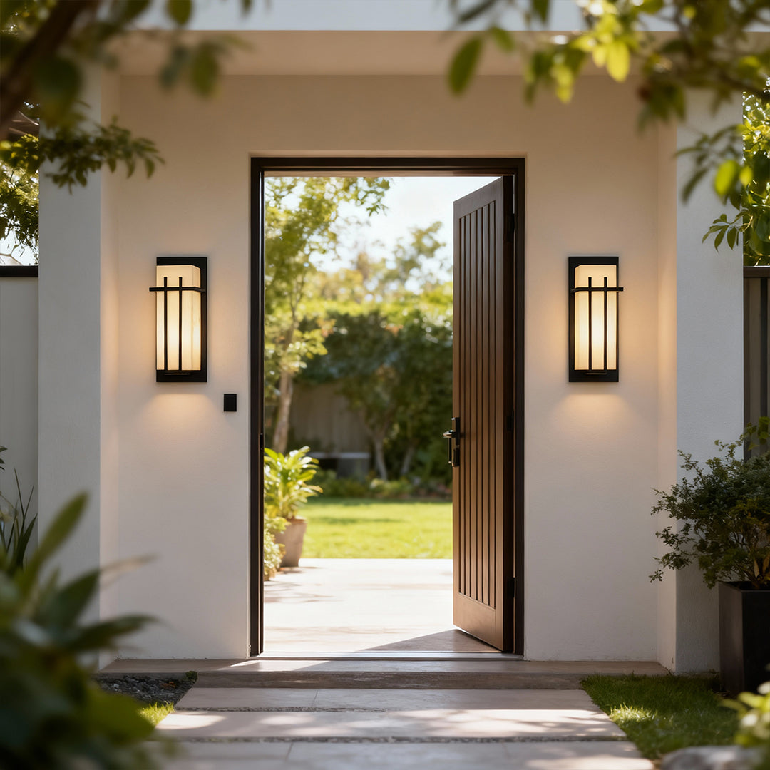 Black wall lights flanking entryway on beige stucco facade providing welcoming illumination in residential setting