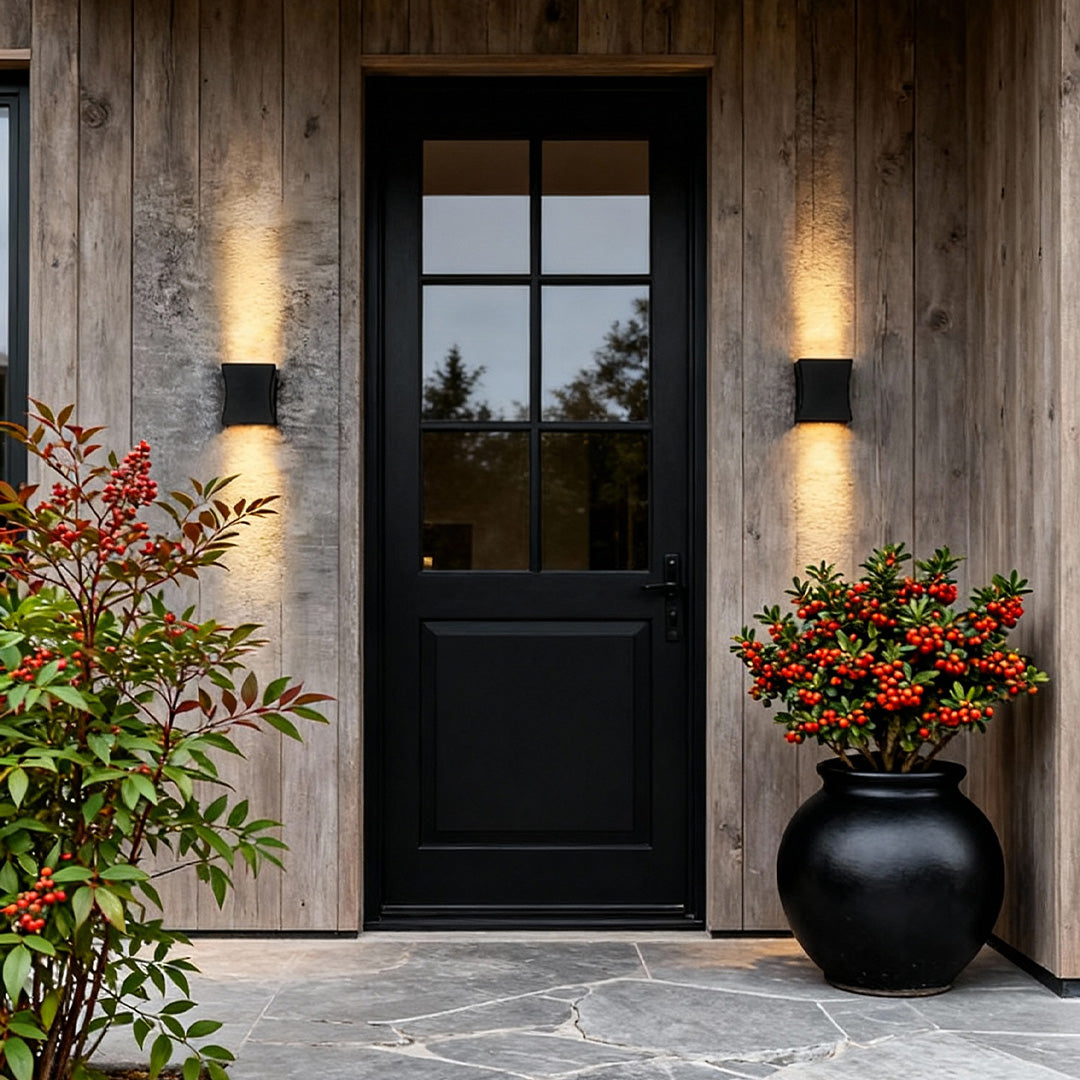 Black wall lights providing soft illumination along a stylish outdoor seating area.