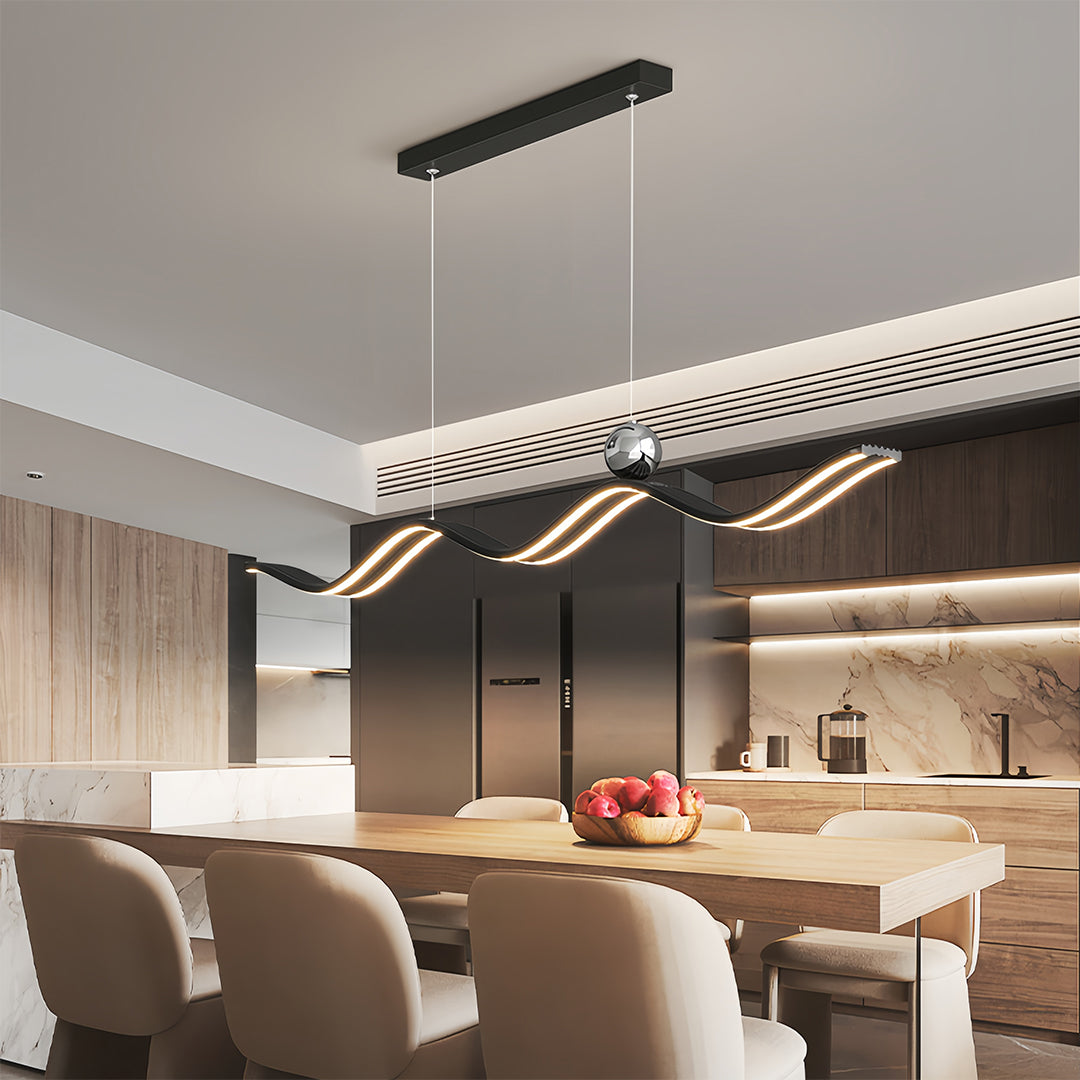 Black wavy linear led pendant light with crystal accent, perfectly mounted over a wooden dining table in a modern kitchen.