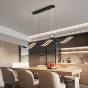 Black wavy linear led pendant light with crystal accent, perfectly mounted over a wooden dining table in a modern kitchen.
