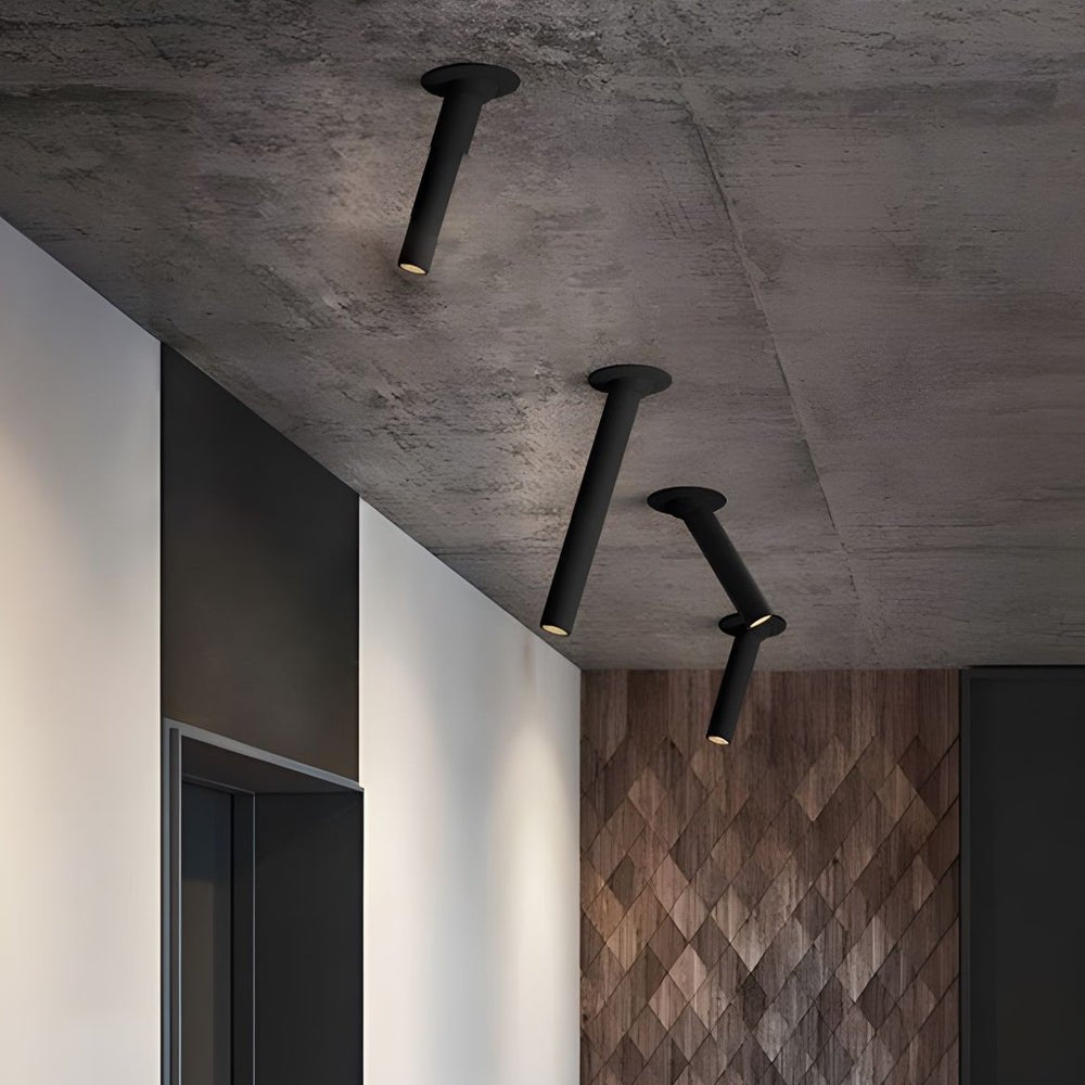 Black and white LED surface spotlights on a concrete ceiling, showcasing industrial chic style in a contemporary setting.