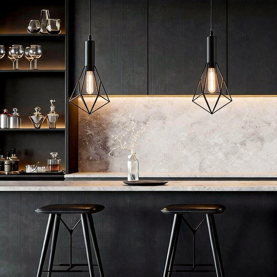 Black wire cage pendant light providing focused illumination above a sleek kitchen island.