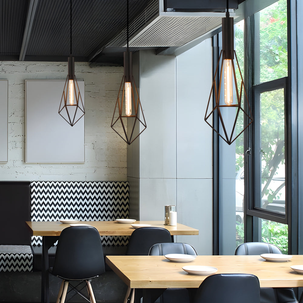 Black wire cage pendant light casting a gentle glow in a modern restaurant setting.
