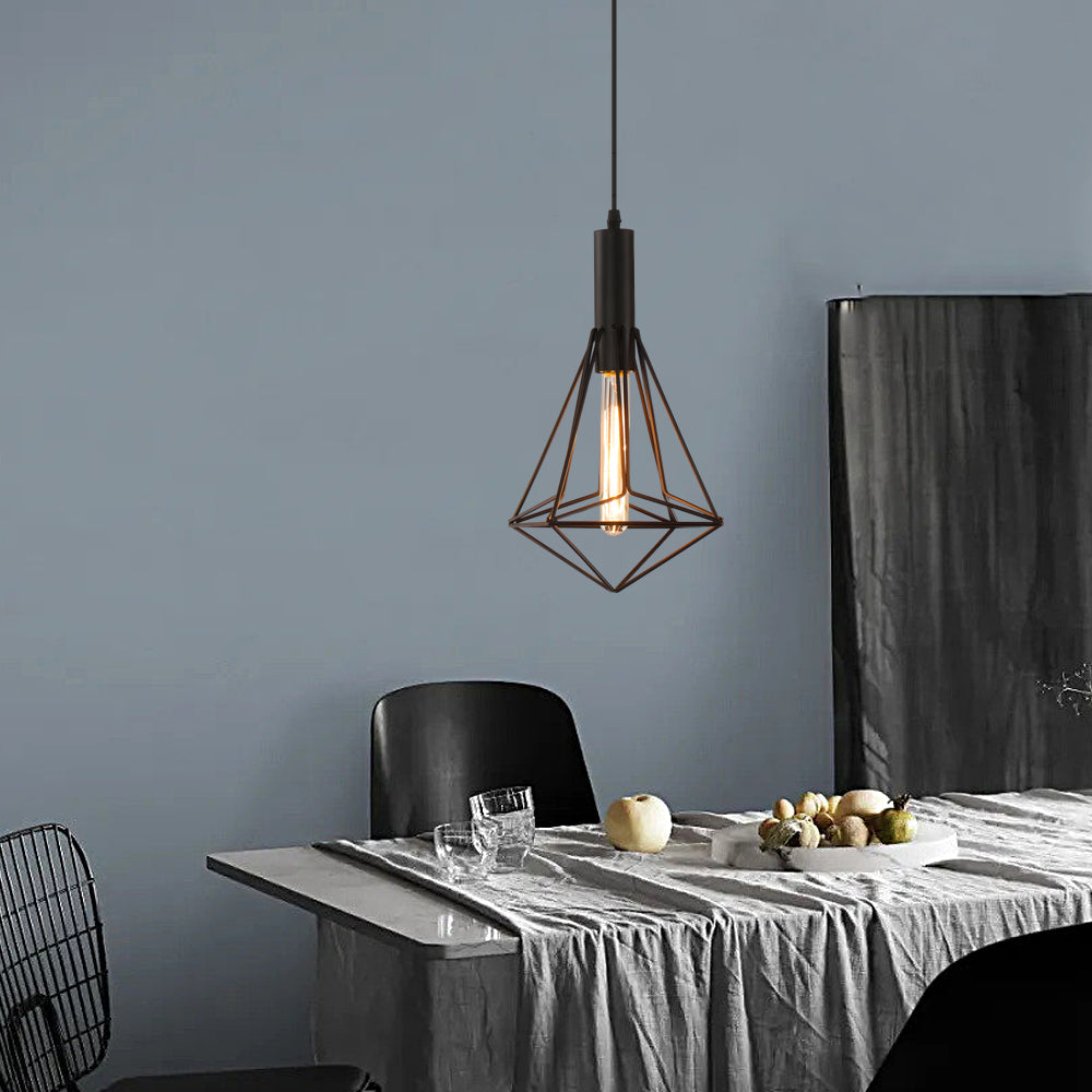 Black wire cage pendant light illuminating a minimalist dining table with elegant light.
