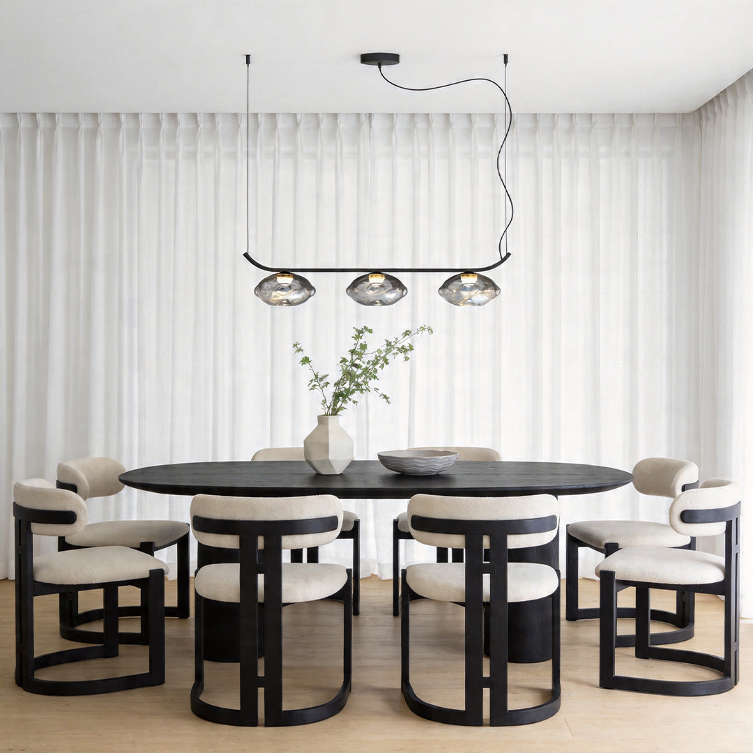 Modern black wrought iron chandelier hanging above a round dining table.
