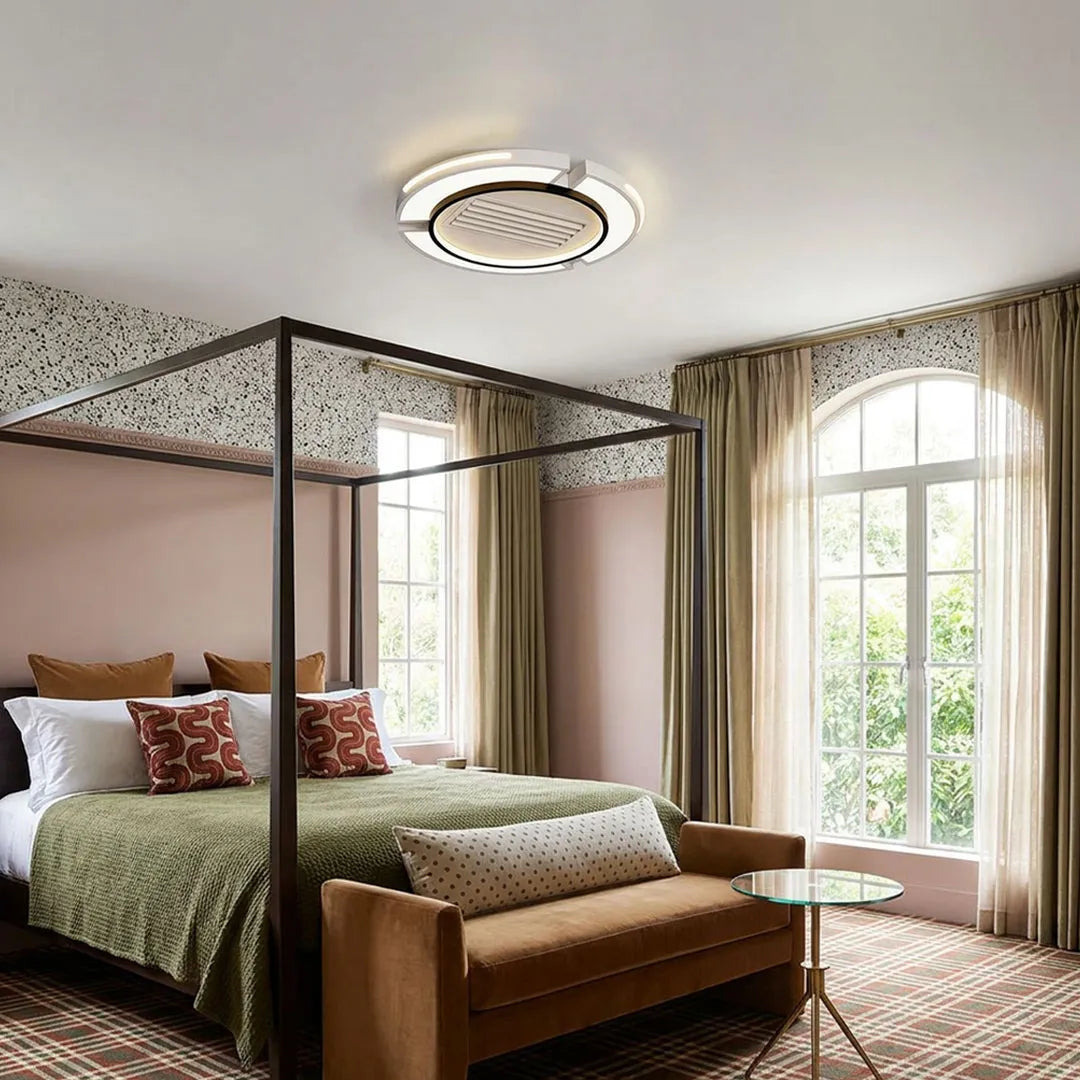 Bladeless ceiling fan with lighting installed in a bedroom featuring a modern round LED ceiling fixture.