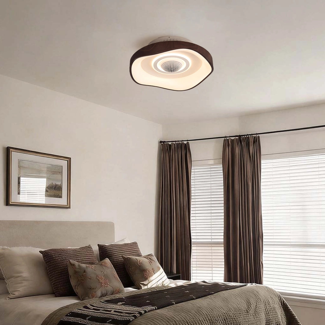 Modern bladeless fan with light mounted on a bedroom ceiling, providing soft LED illumination above the bed.
