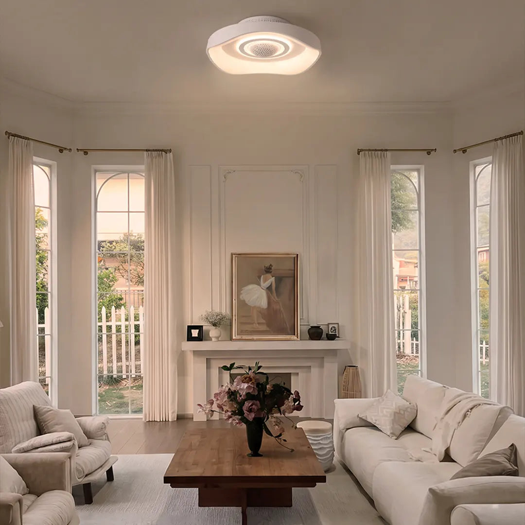 Bladeless fan with light installed in a bright living room with tall windows, white sofas, and a wood table.