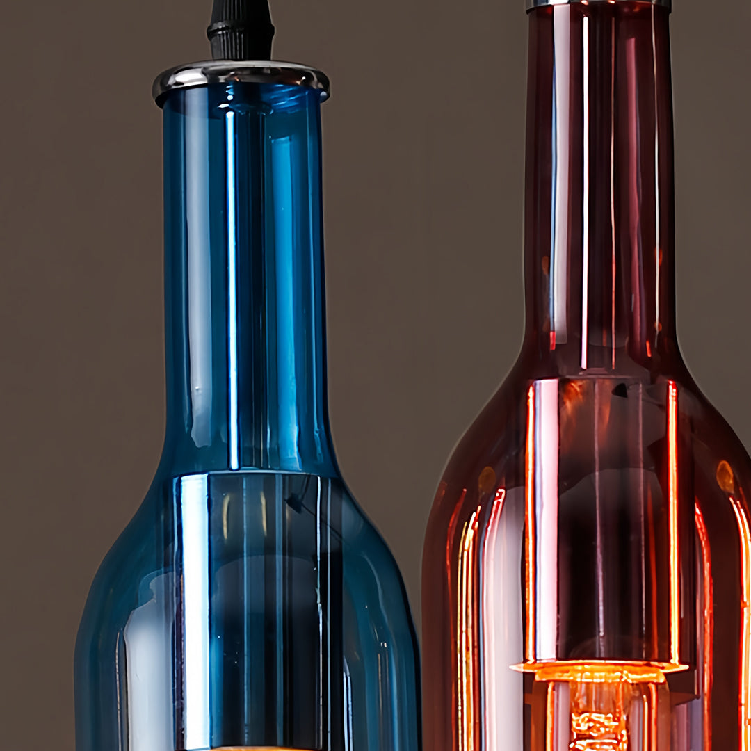 Blue and burgundy wine bottle pendant lights grouped together showing reflective glass surfaces