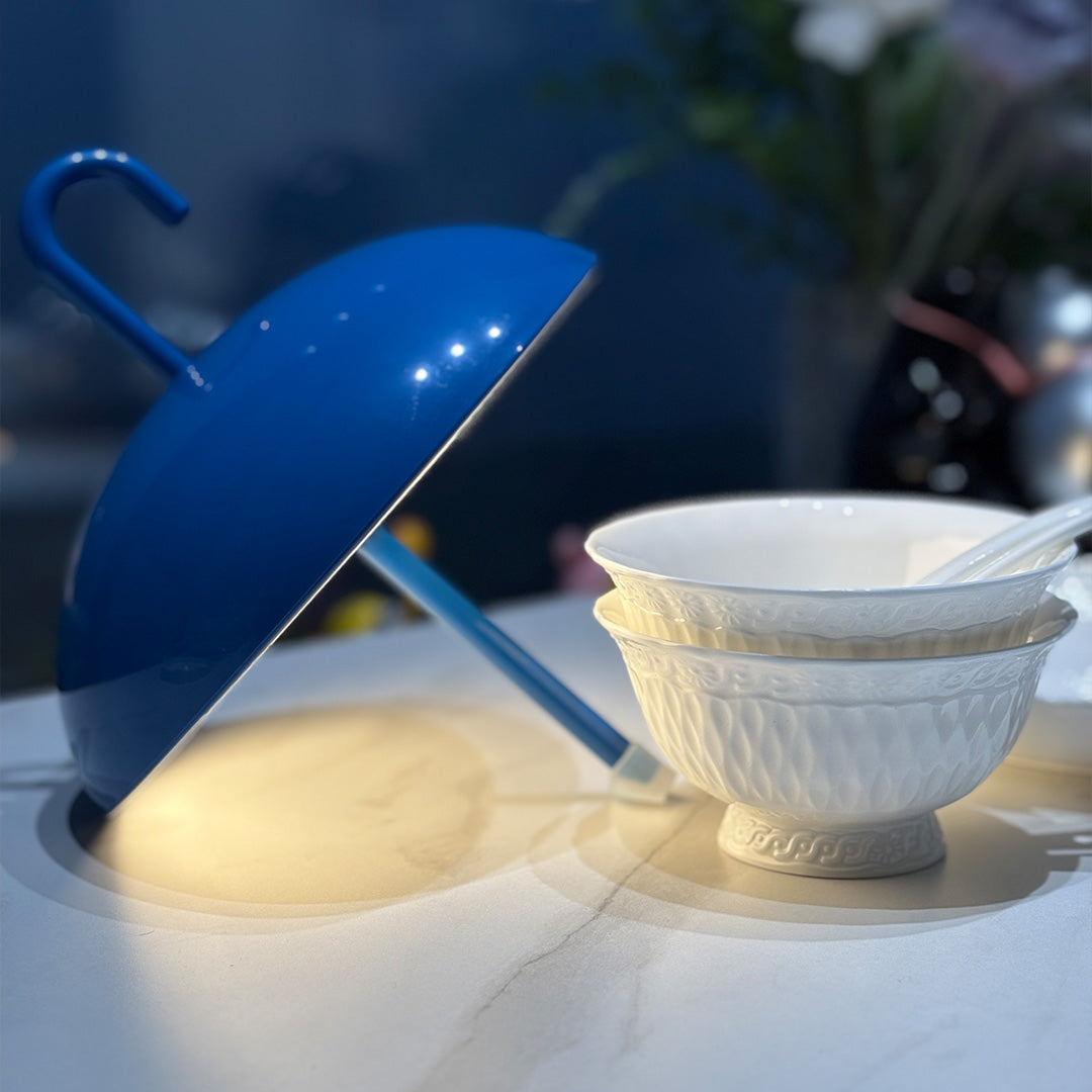 Blue dome USB rechargeable table lamp next to bowl demonstrating compact dining lighting