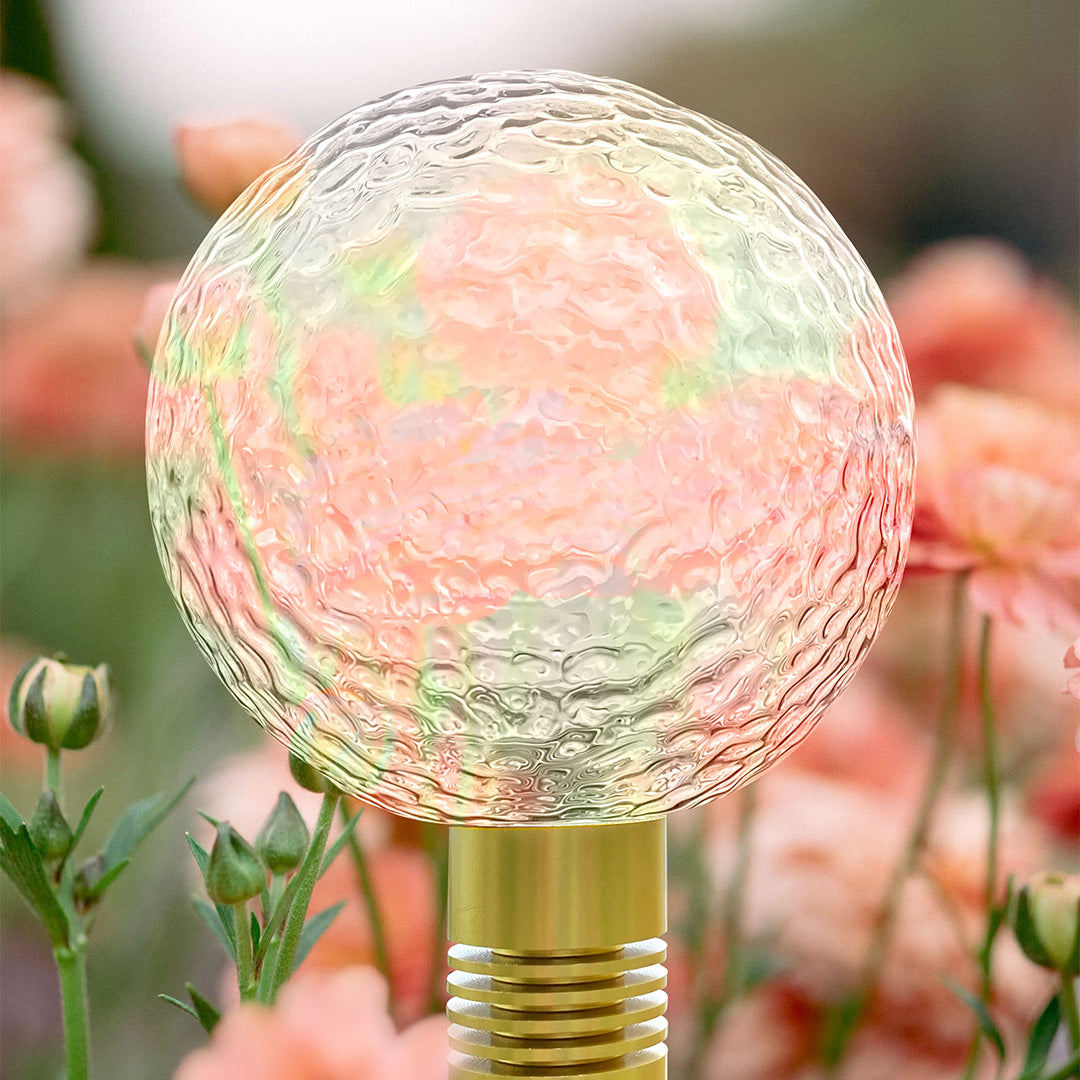 Blue crackle-glass garden stake light adding cool-toned illumination for path landscape lighting.