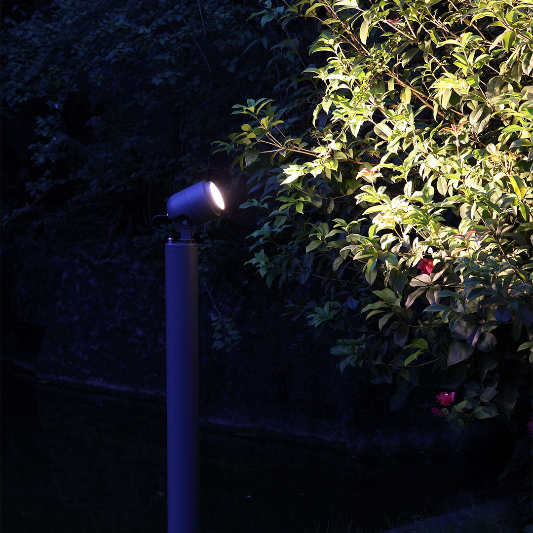 Blue LED bollard light illuminating garden plants and foliage during nighttime outdoor setting