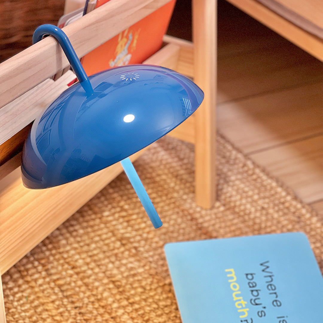 Blue USB rechargeable table lamp on wooden surface showing practical everyday use