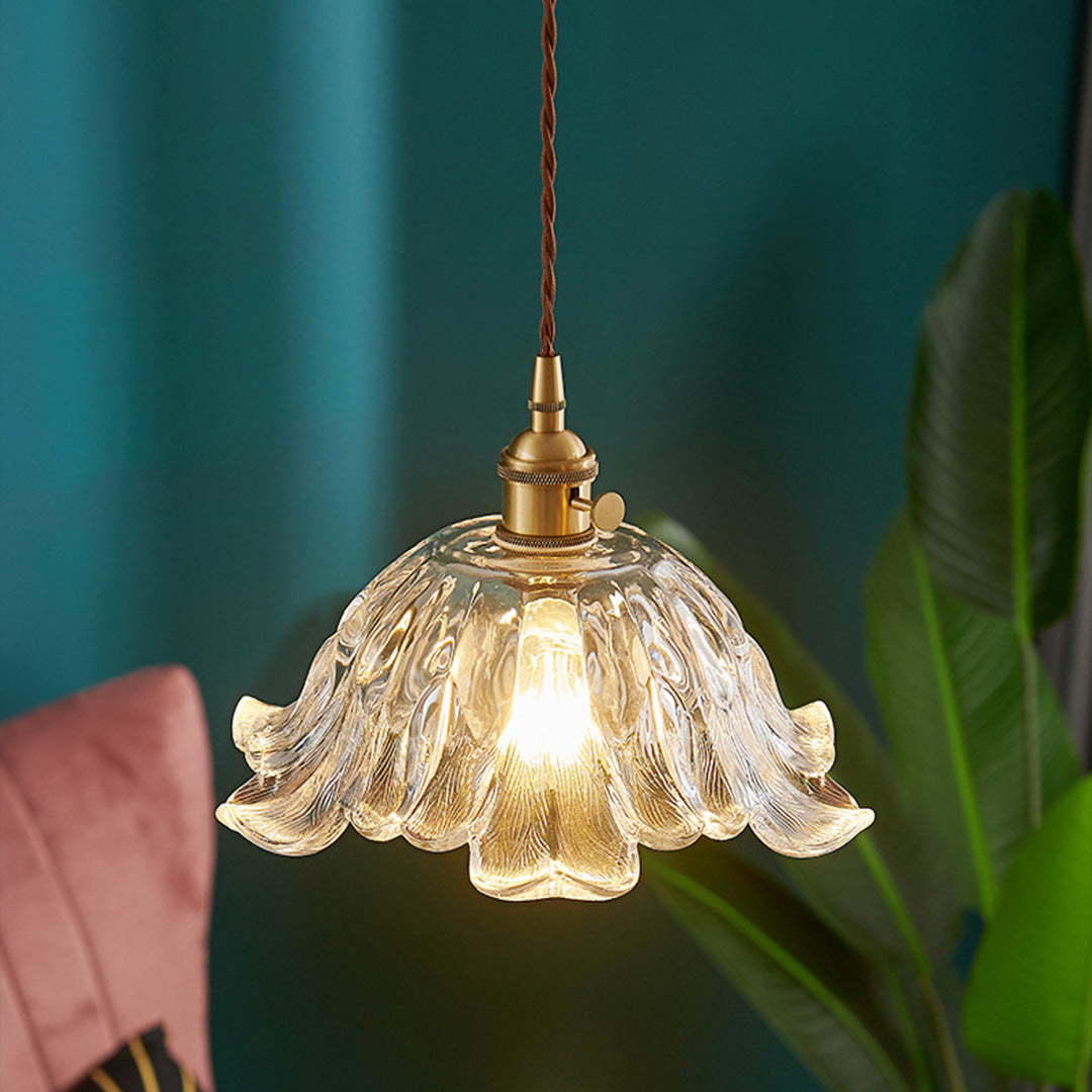 Bohemian style flower pendant lighting with textured glass shade against vibrant teal accent wall.