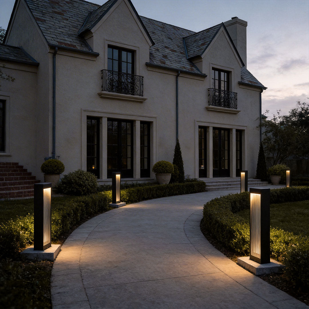 Bollard garden lights with a modern design, lighting up a curved driveway.