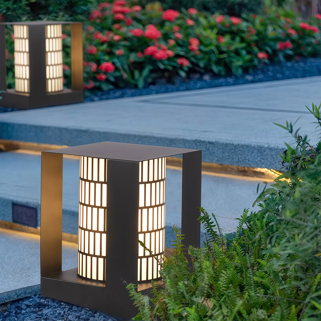 LED bollard landscape light beside a flower bed, providing soft illumination to highlight garden plants.