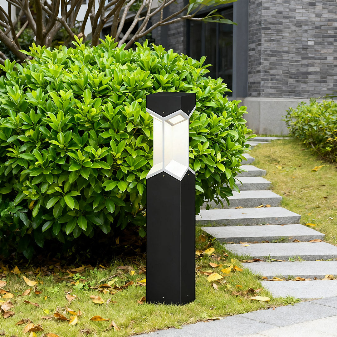 Bollard landscape light installed along a garden pathway, providing warm illumination.