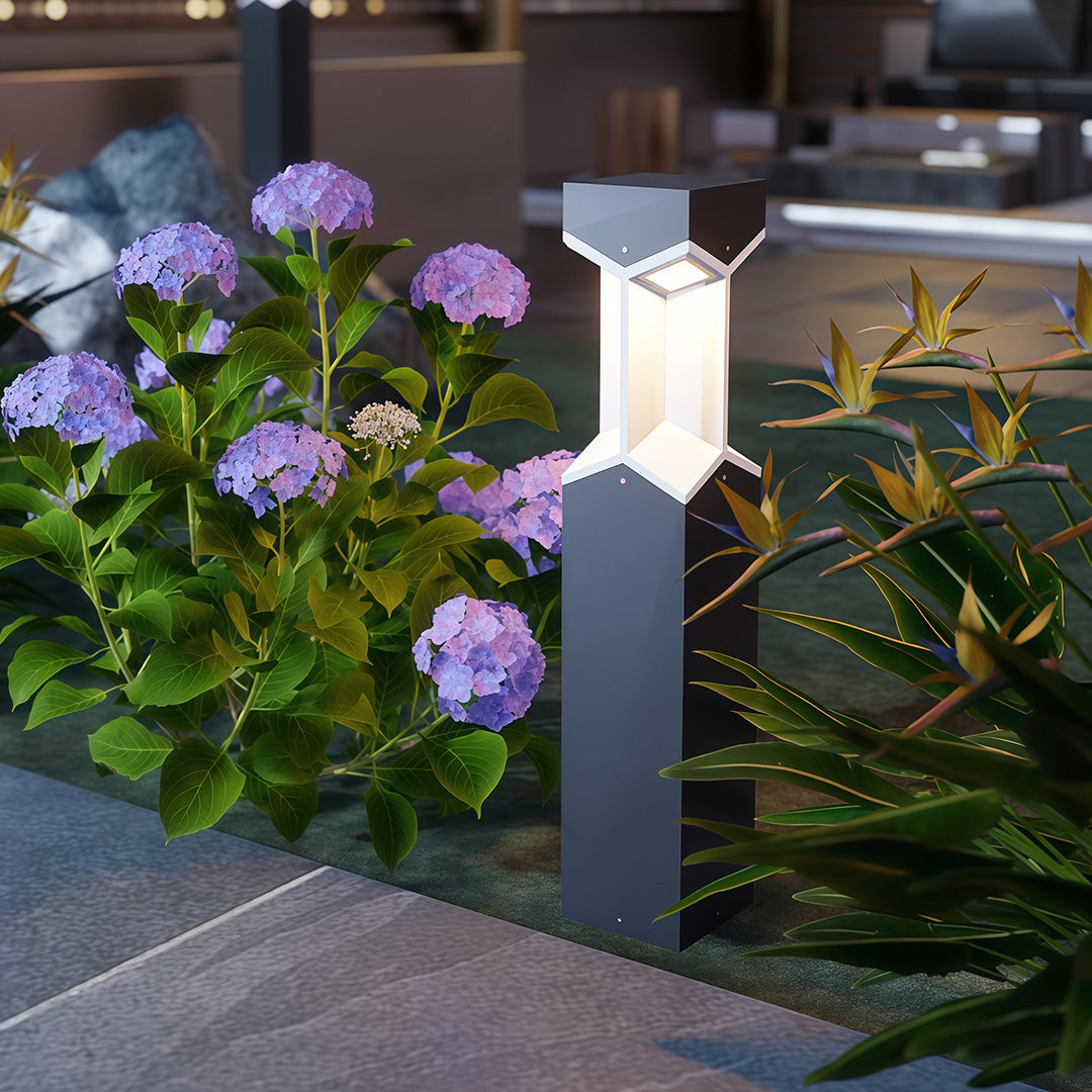 Bollard landscape light along a pathway near a modern building, providing a welcoming ambiance.