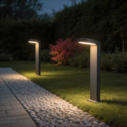 Bollard landscape lights illuminating a modern garden pathway with warm directional glow.