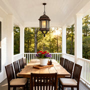 Bollard LED light fixture casting glow over screened porch dining area with dark wood furniture