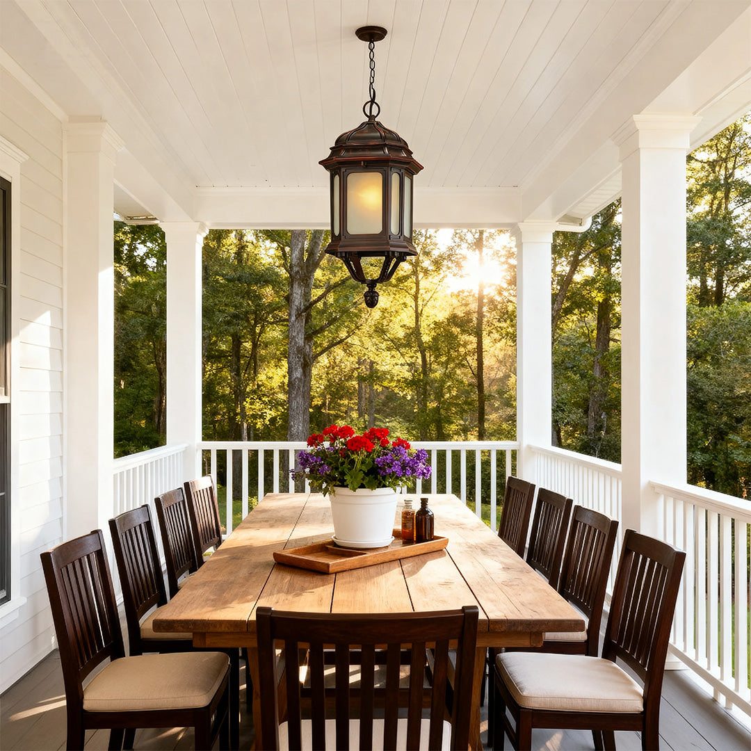 Bollard LED light fixture casting glow over screened porch dining area with dark wood furniture