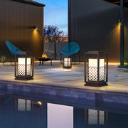 Bollard light fixture with geometric lattice pattern, placed along the edge of a water feature to enhance the scenery.