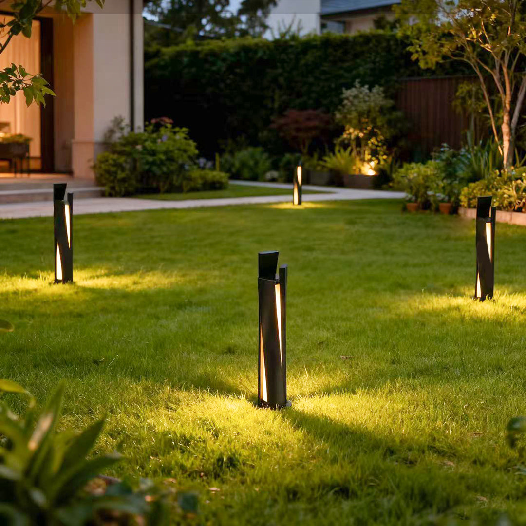 Bollard lighting fixtures creating ambient glow across residential lawn area near house at evening time