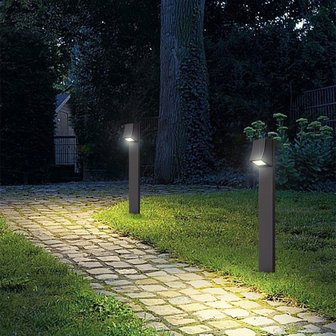 Outdoor bollard lights illuminating a stone garden path at night