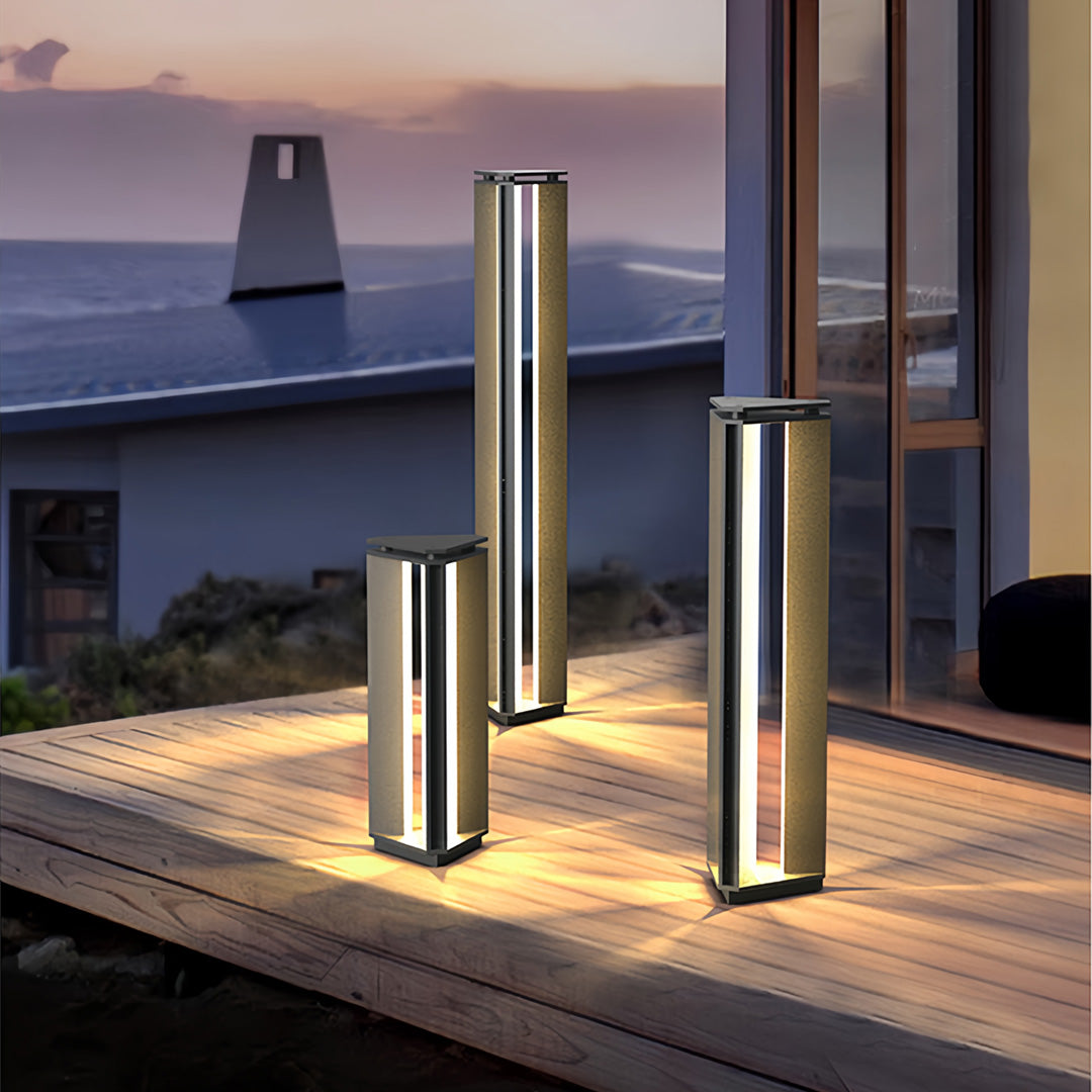 Dual-height bollard outdoor lights illuminating a modern outdoor terrace area at sunset.