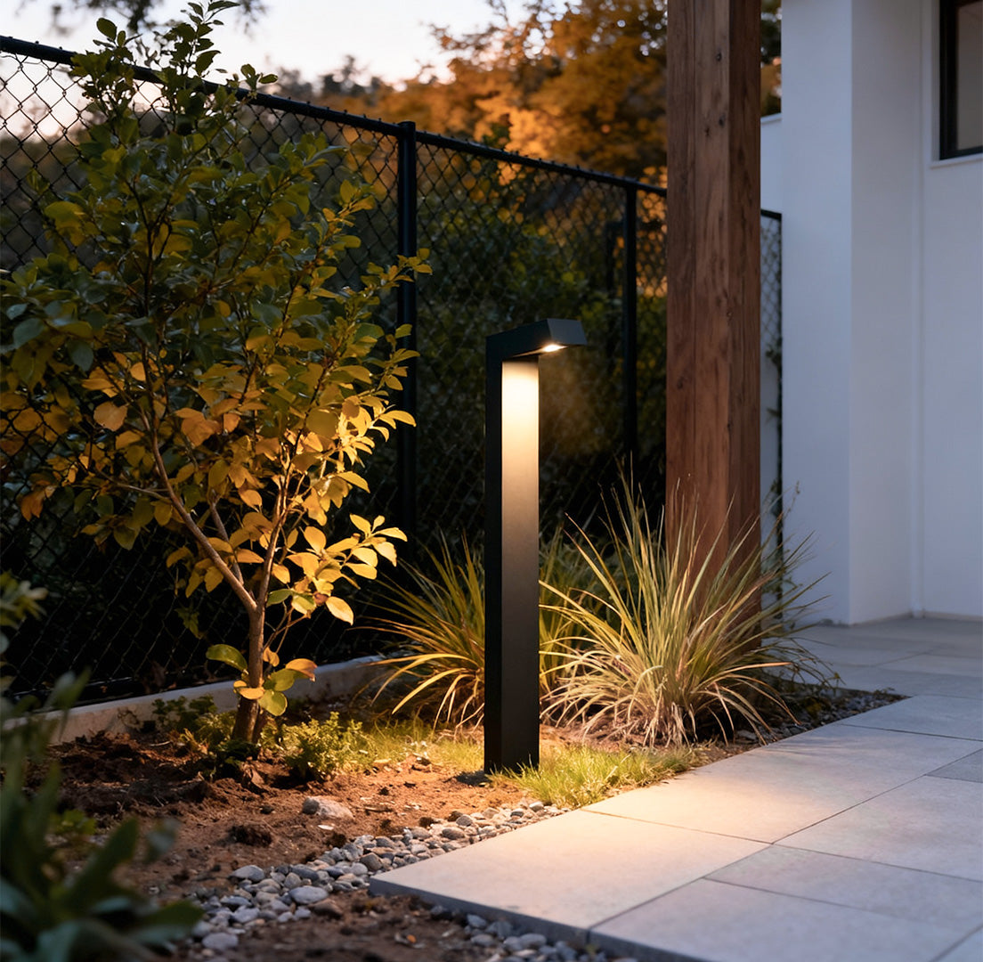 Bollard path light illuminating a garden pathway, providing subtle and functional outdoor lighting.