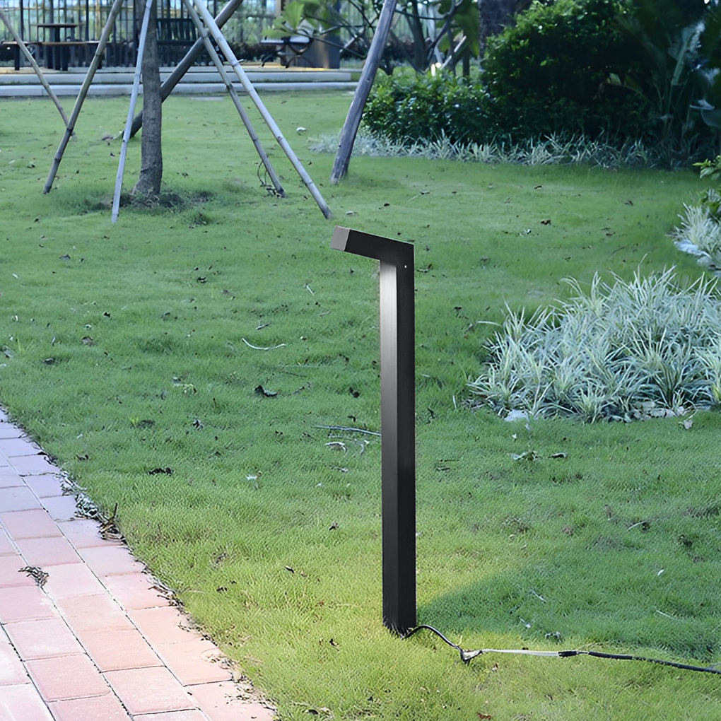 Bollard path light beside a green lawn, offering a modern and minimalist outdoor lighting solution.