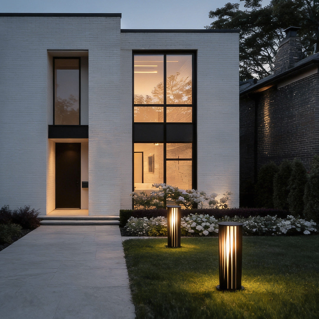 Modern bollard path lights placed along a front yard entrance pathway at dusk.