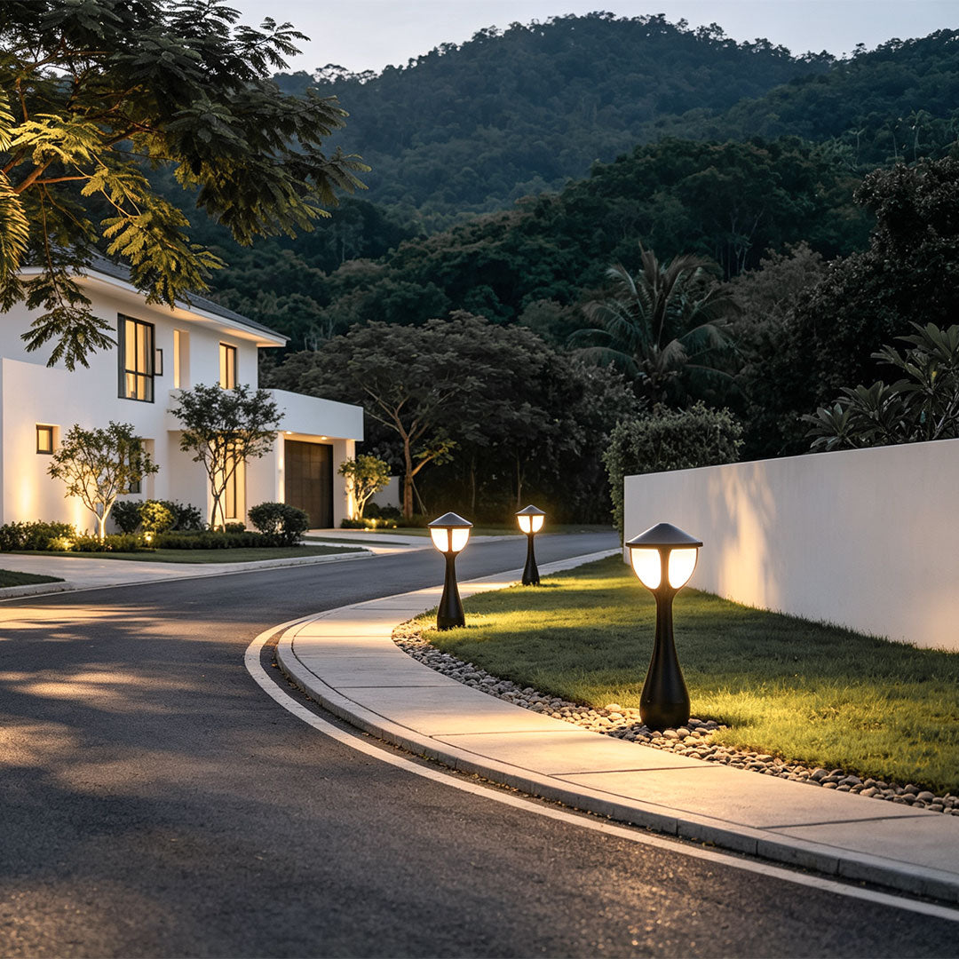 Bollard path lights illuminating a garden lawn edge with warm LED outdoor pathway lighting.