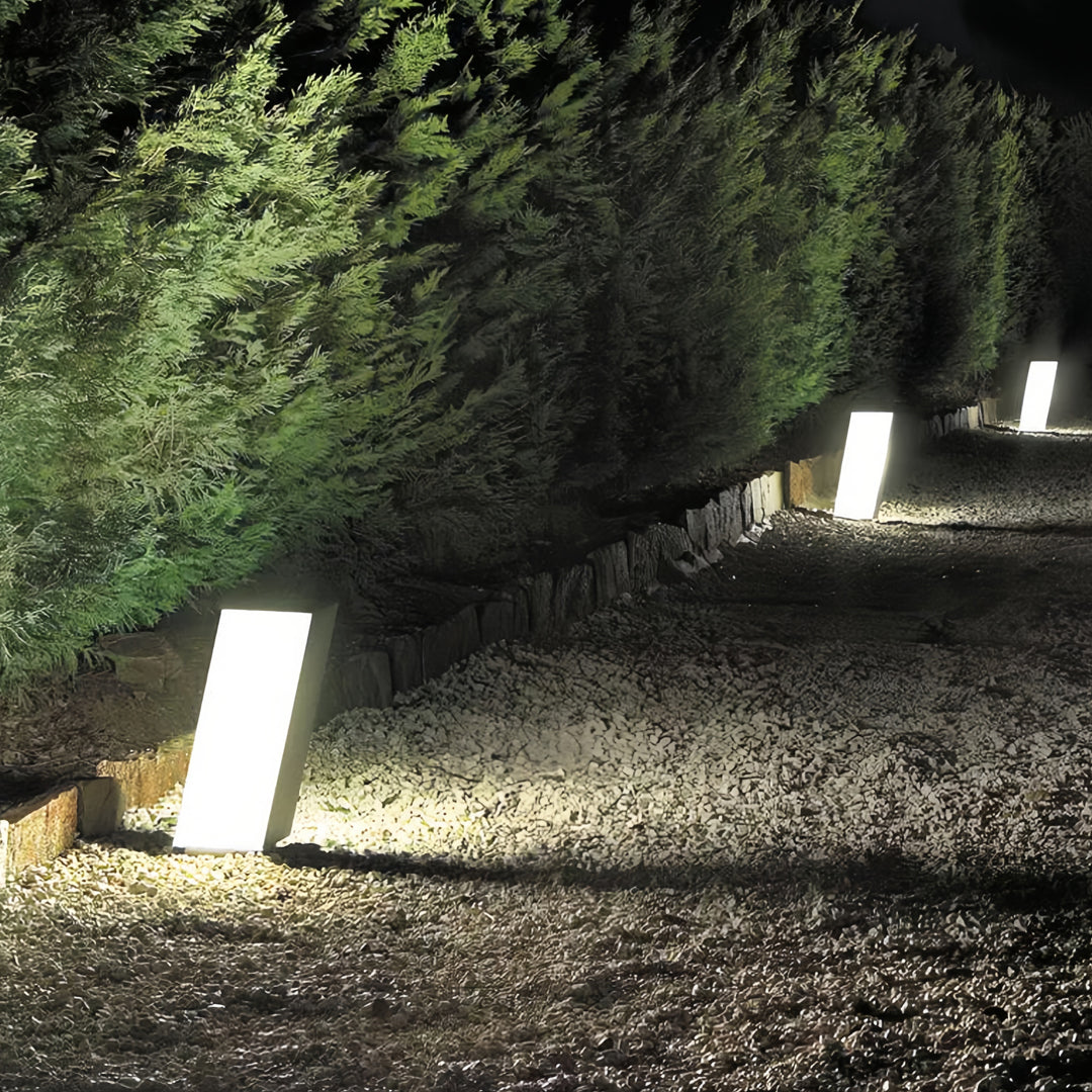 Outdoor bollards with lighting lining a garden path, creating a warm nighttime landscape effect.
