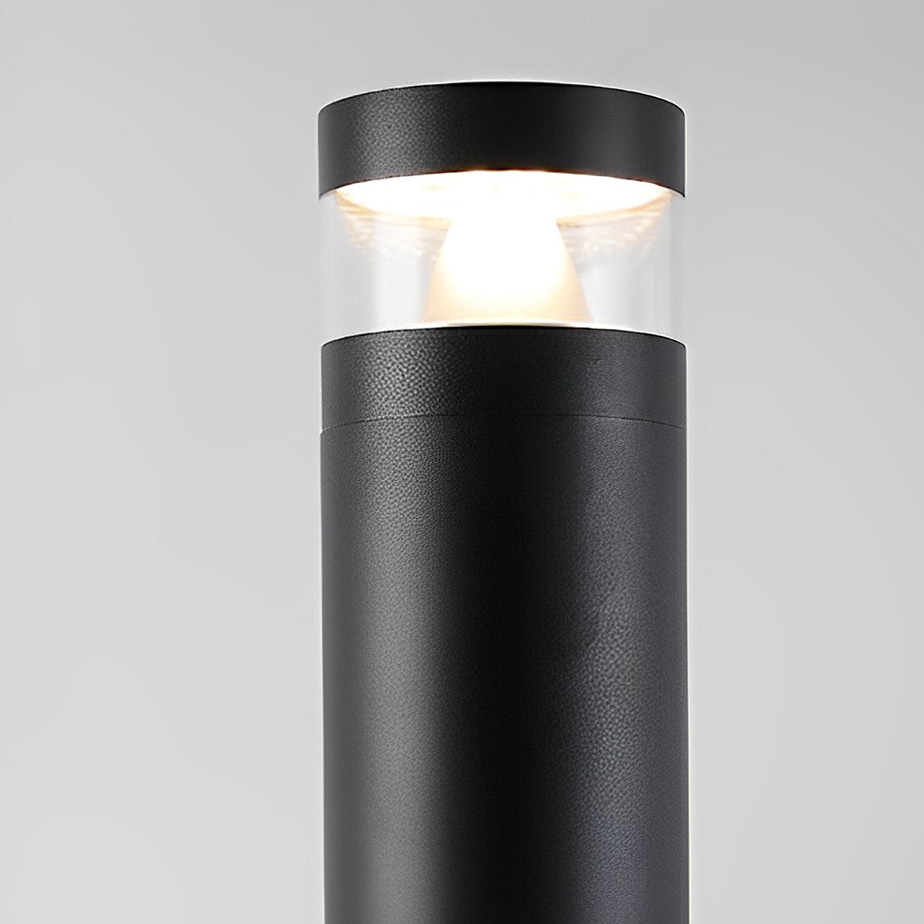 Close-up of bollards with lights featuring a black cylindrical body and clear upper diffuser.