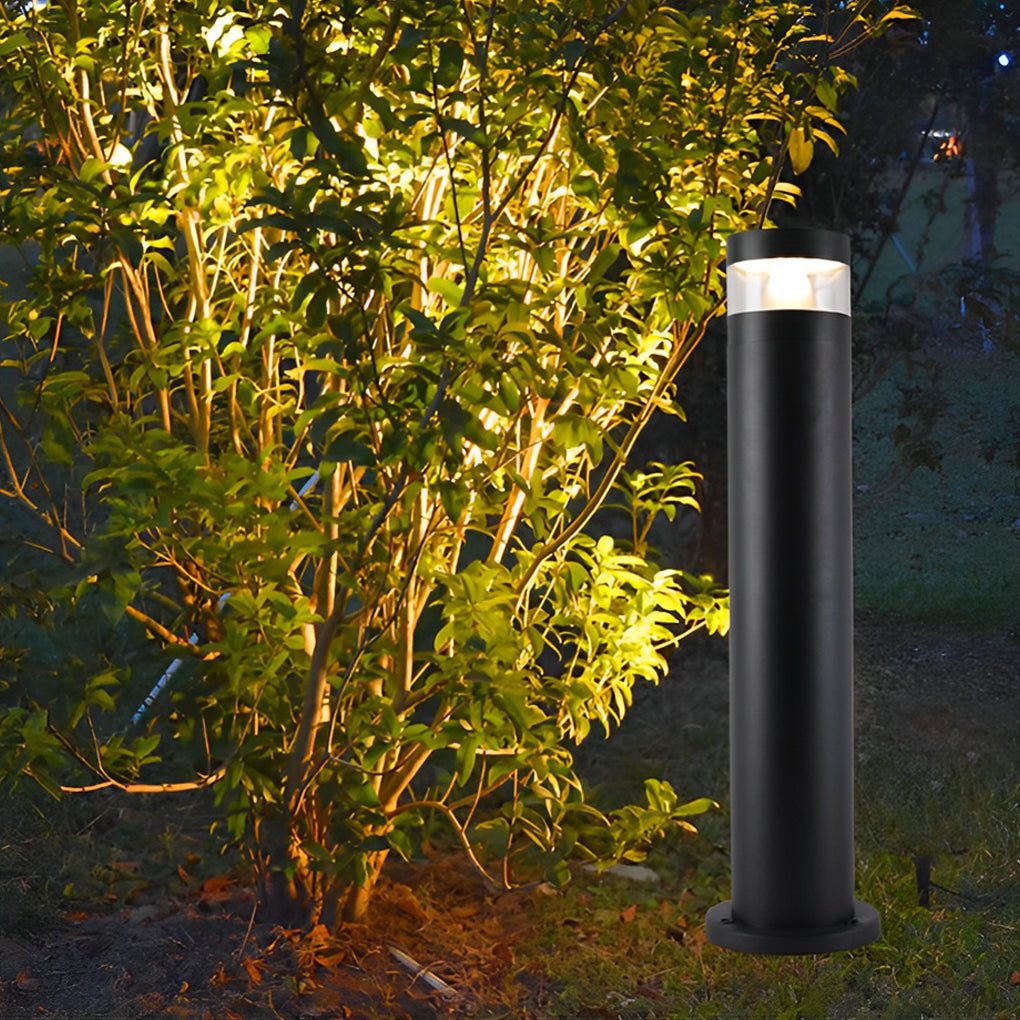 Bollards with lights providing warm uplighting near shrubs and garden plants at night.