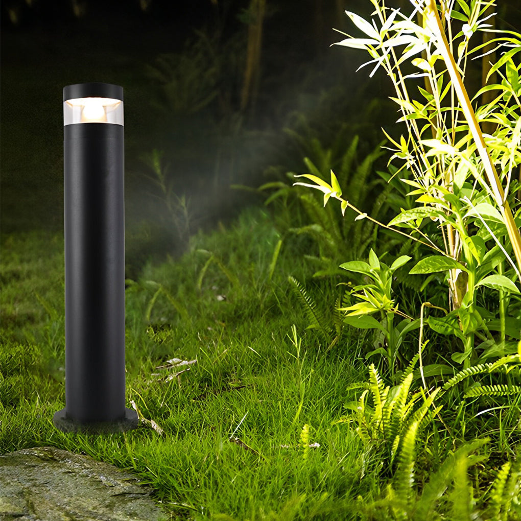 Bollards with lights installed in a grassy landscape bed to highlight plants and pathways.