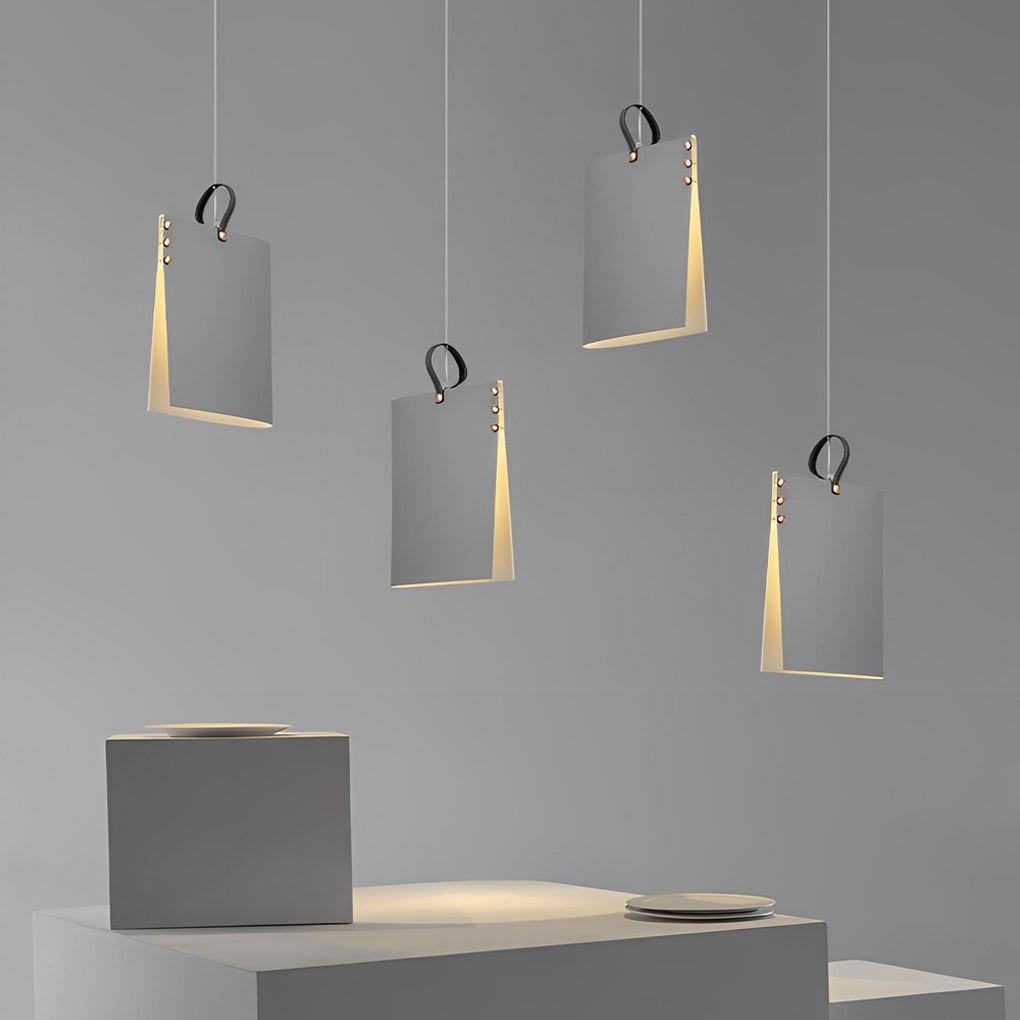 Artistic book pendant light installation with multiple hanging fixtures, creating a gallery-style lighting composition.