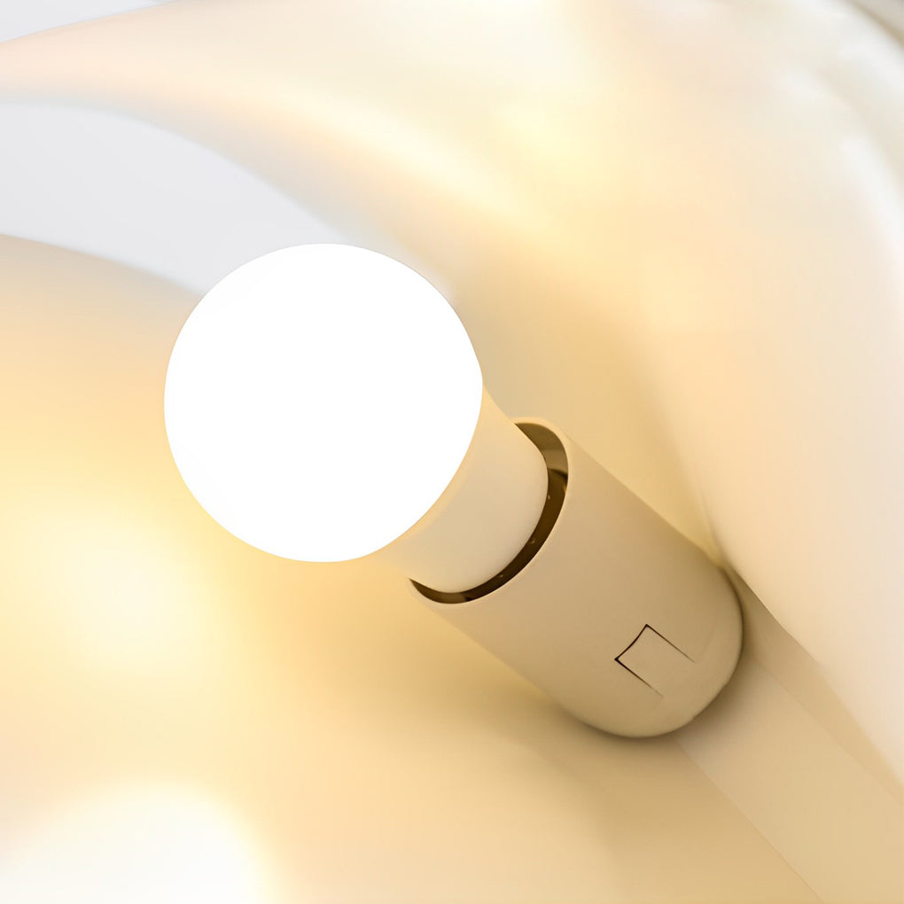 Close-up of bulb inside book pendant light, revealing warm glow and modern internal structure.