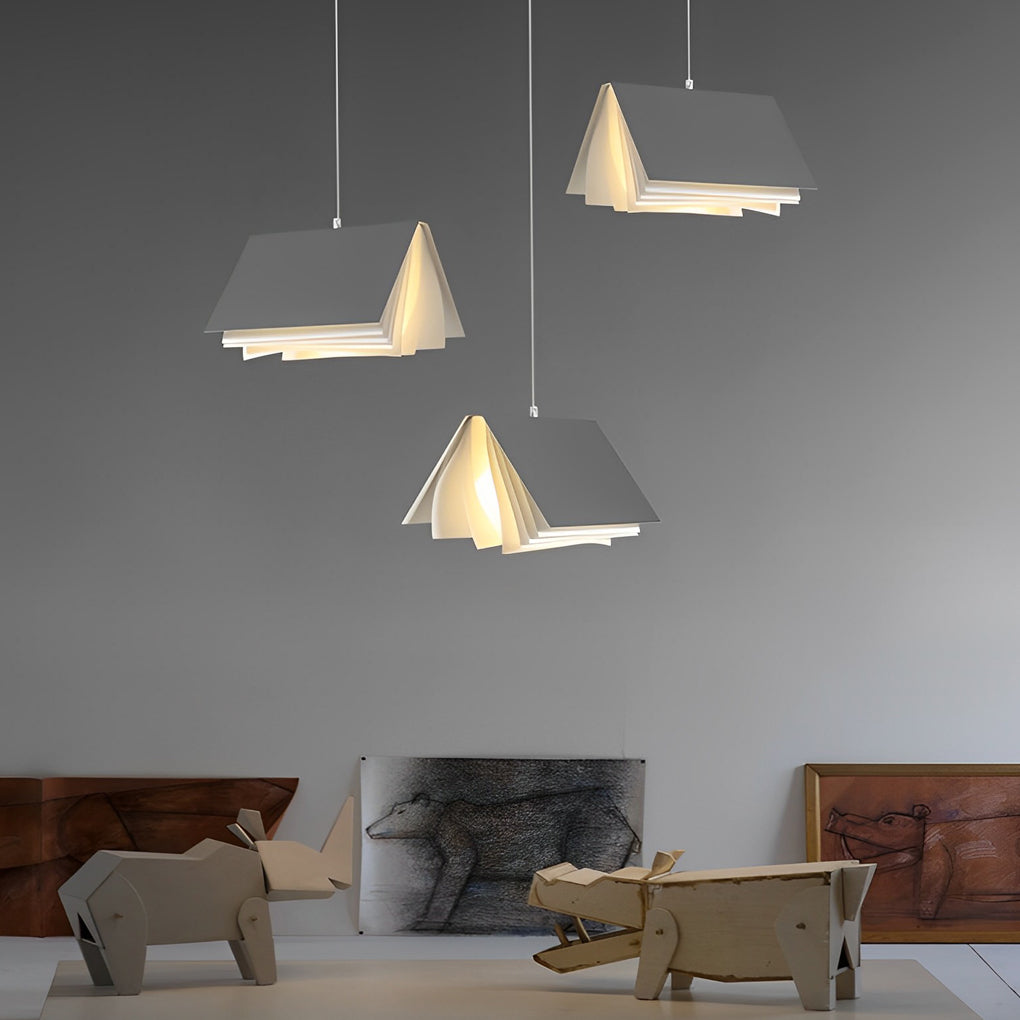 Elegant book pendant light arrangement in a neutral living space, offering warm illumination through layered book-form panels.