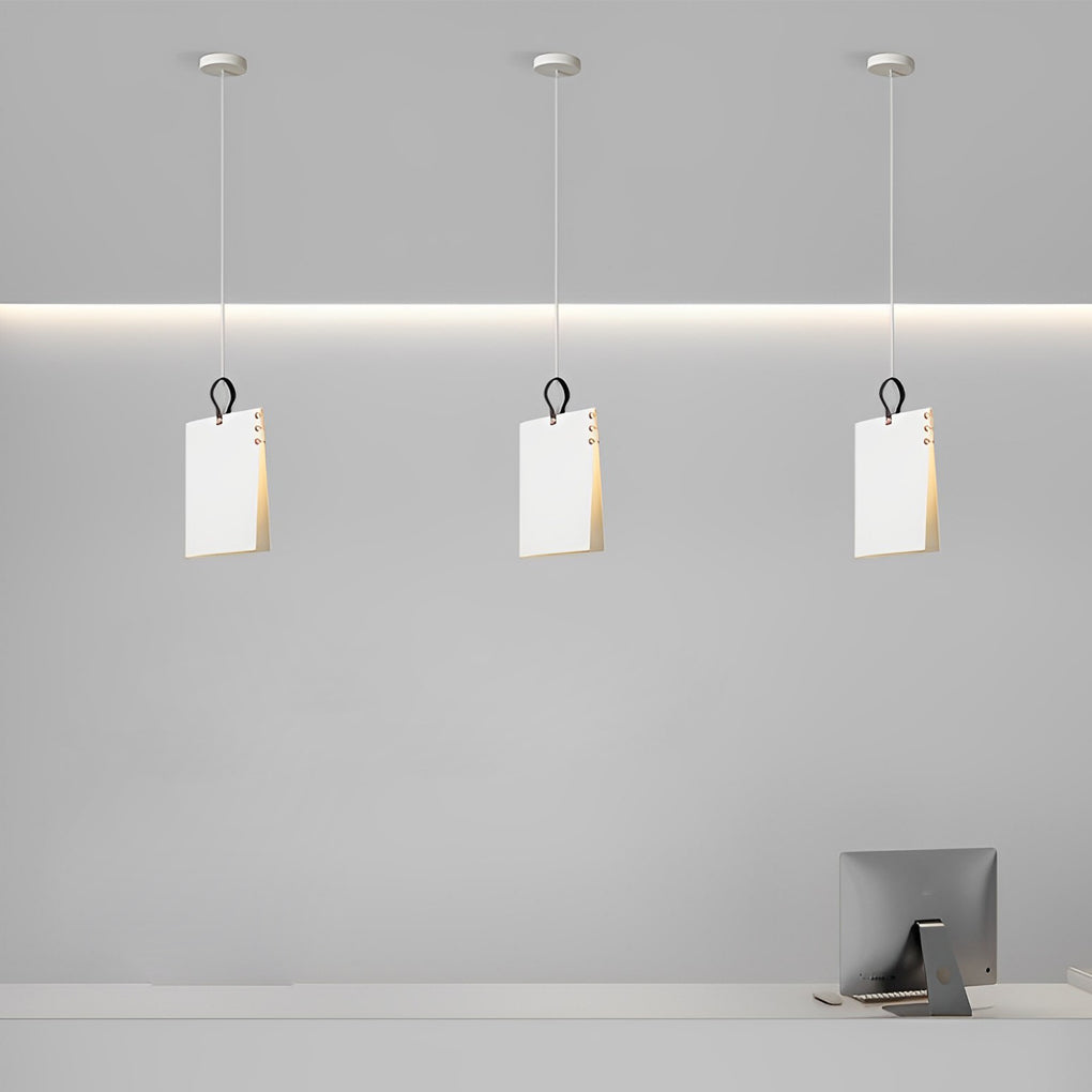 Minimal book pendant light trio suspended in a row, highlighting clean geometry and soft downward illumination.